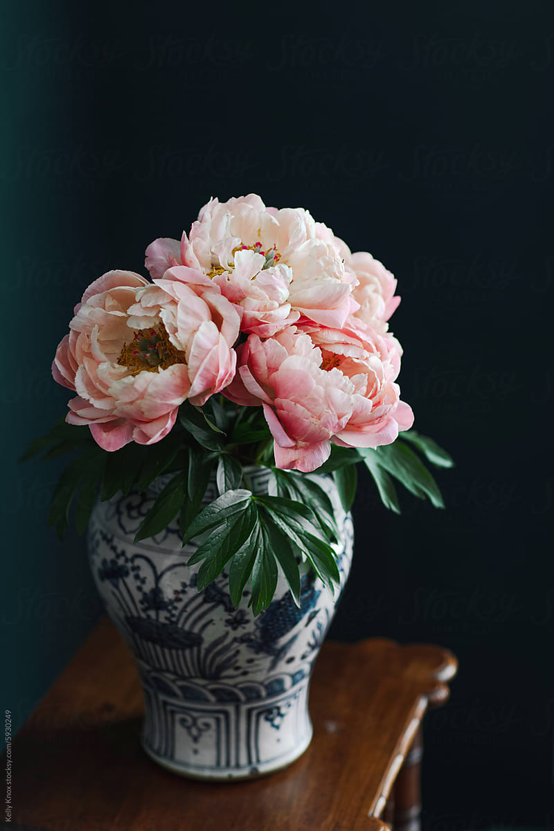 coral charm peony blooms in a large vase