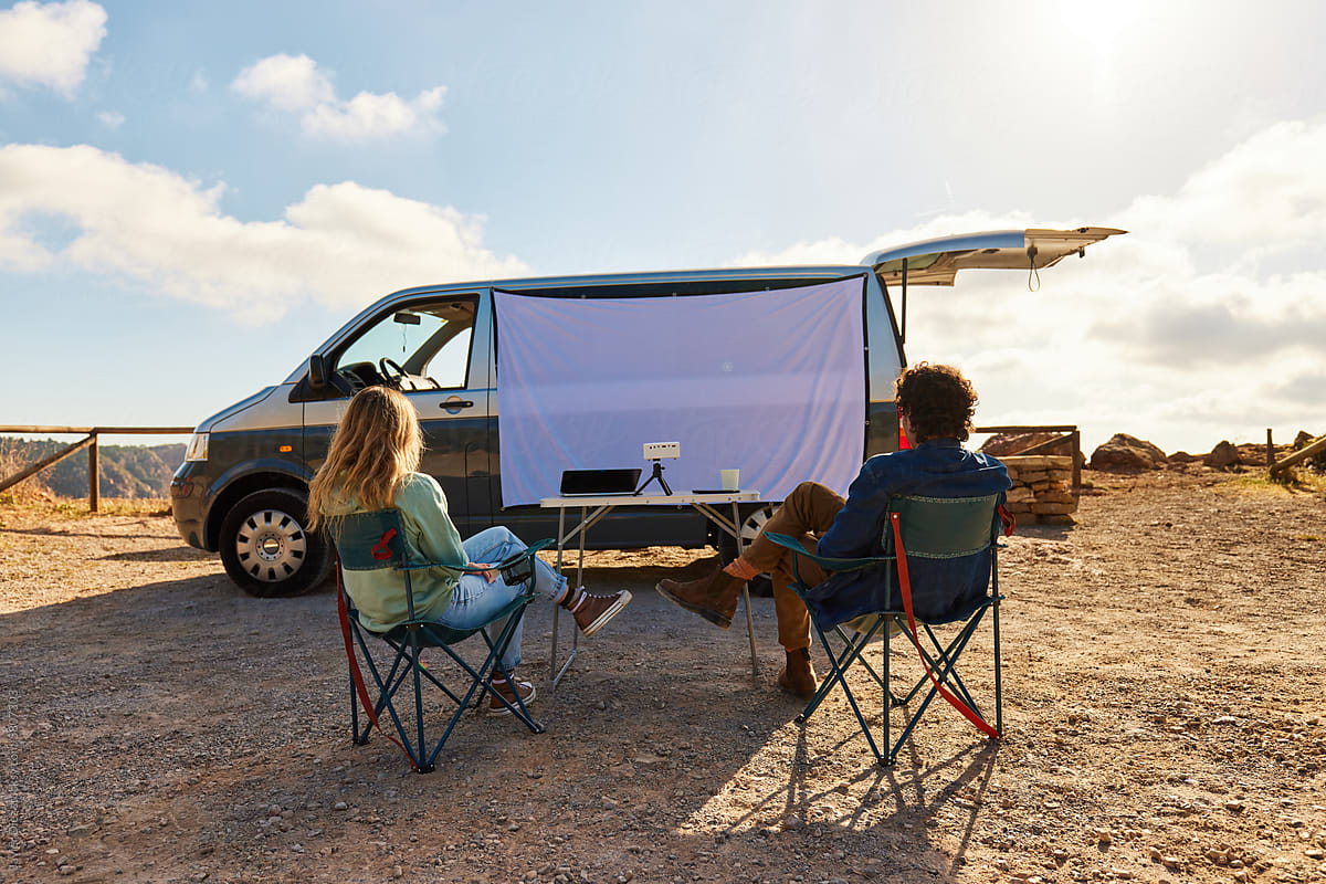Young couple watching film in camper