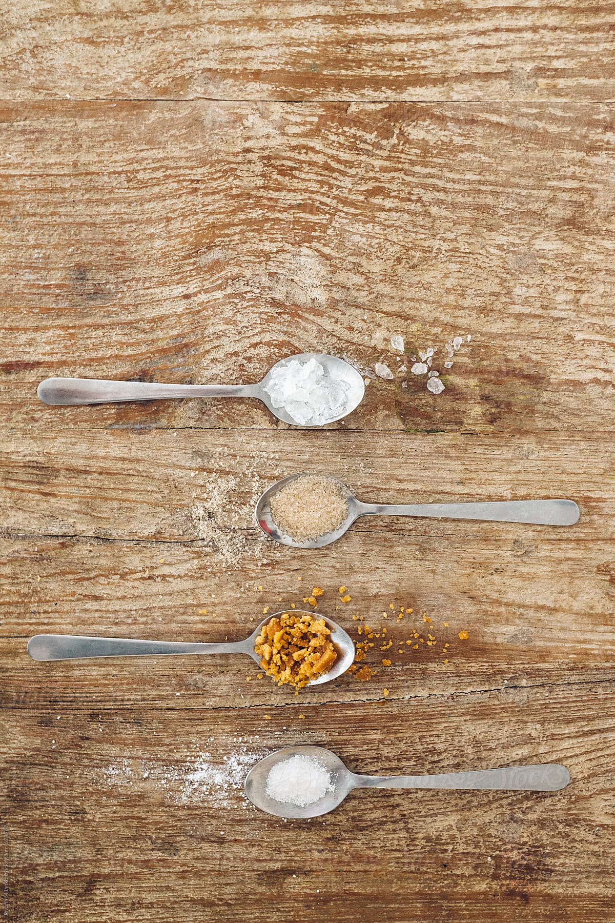 Teaspoons holding four kinds of sugar
