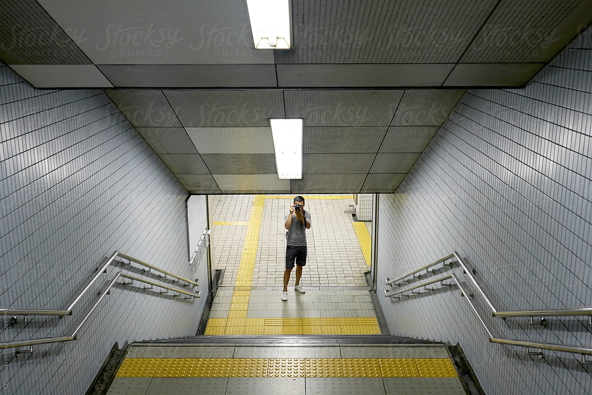 Asian photographer in the road route, ladder in the subway station