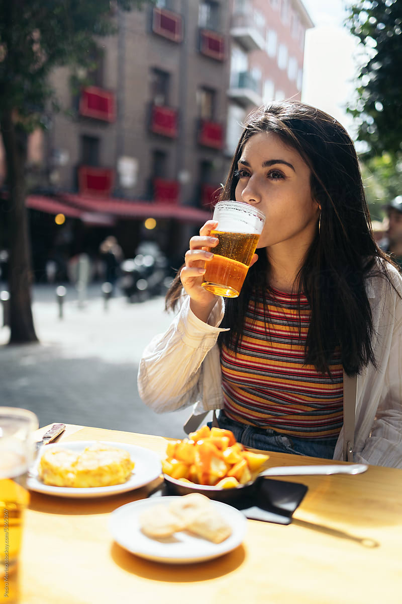 Woman having beer and some tapas in Madrid, Spain