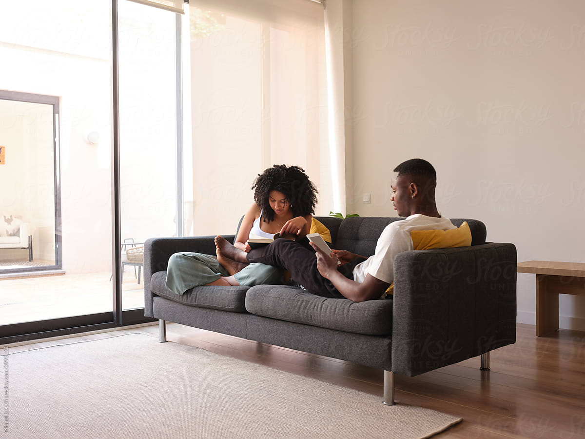 Black couple spending free time on couch.