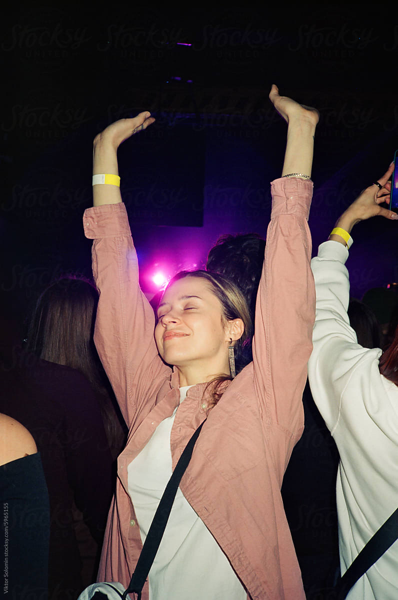 Young woman with raised arms on concert