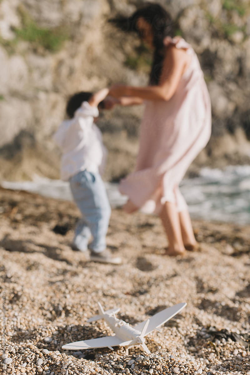 Mother Dancing with Her Son on the Beach Near Ocean in summer