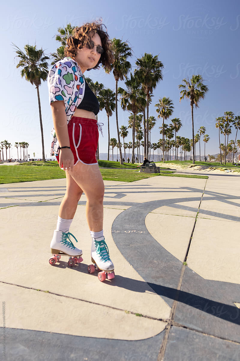 Non-binary person in roller skates at the beach
