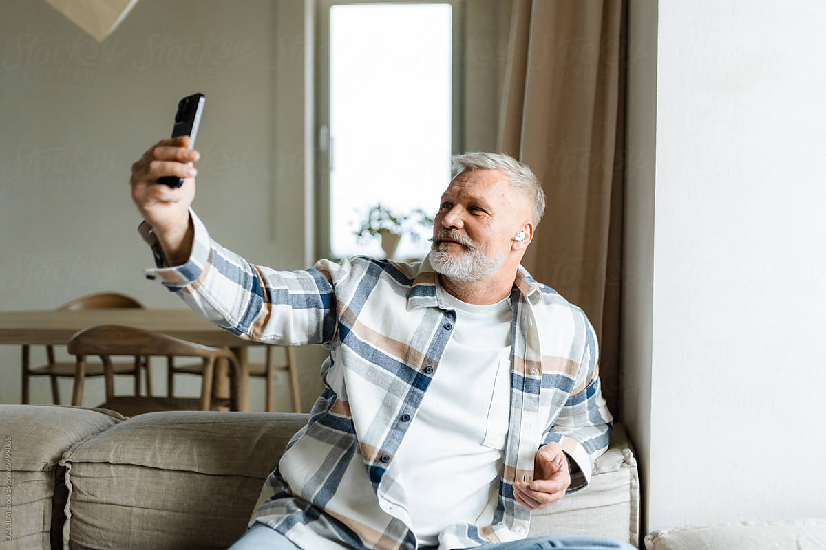 A man uses a mobile phone at home