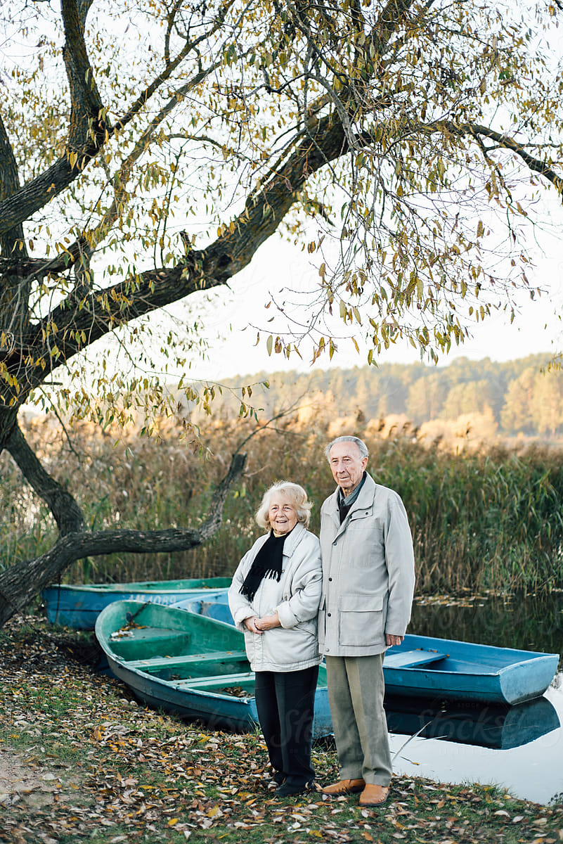 Loving senior couple on lake shore in autumn