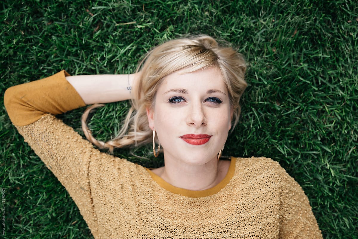 Young Blond Woman Lying In Grass By Stocksy Contributor Vera Lair