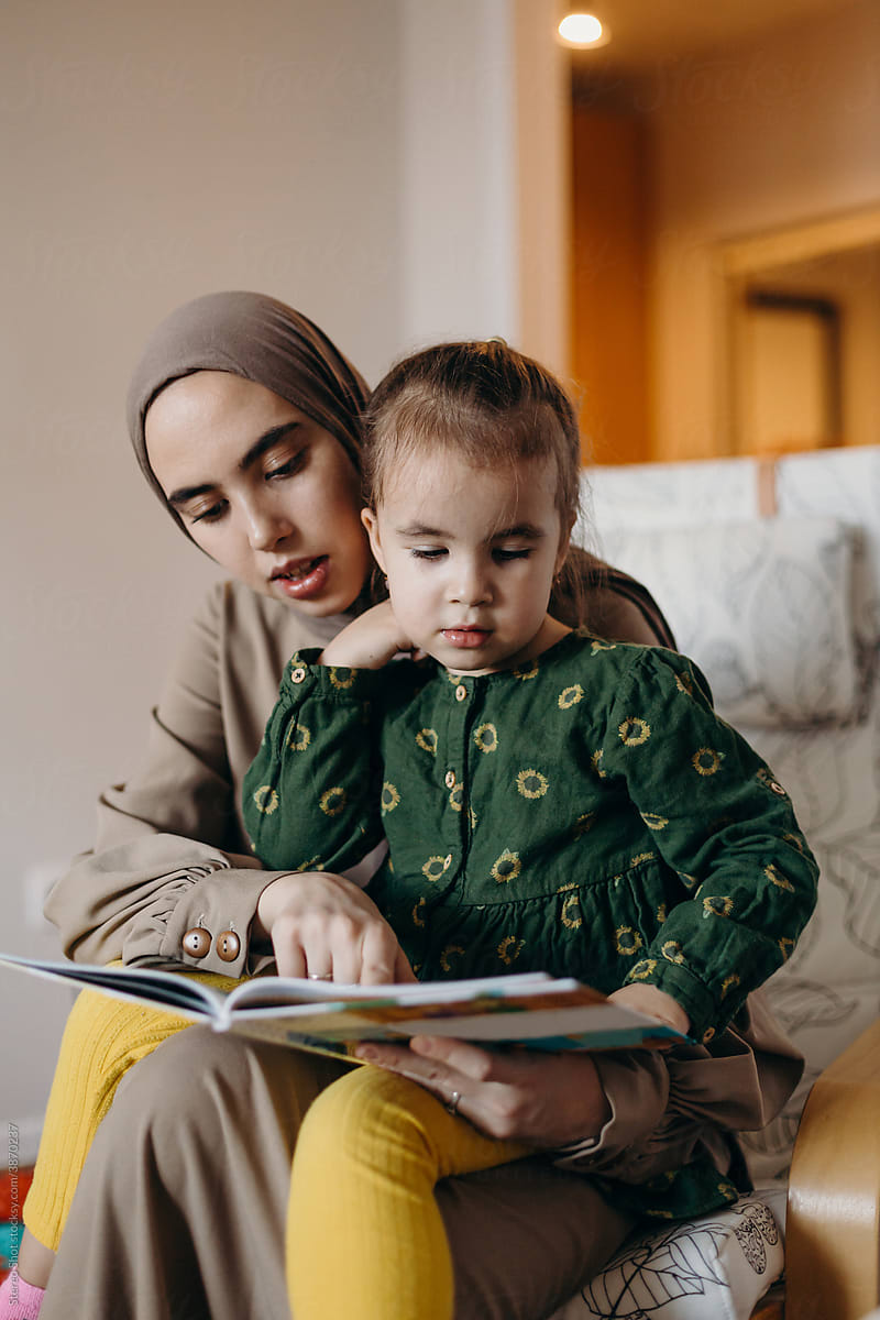 Islamic mother with kid reading book