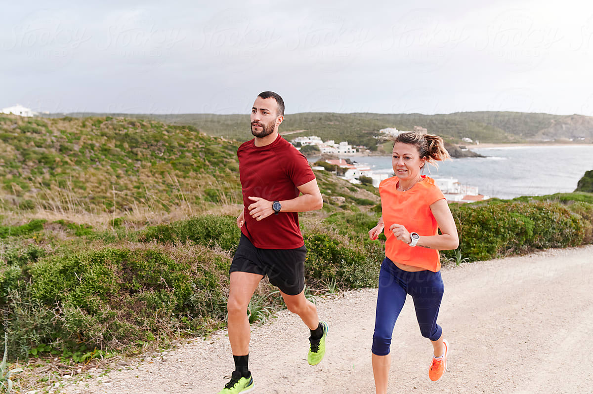 Couple running together by the coast
