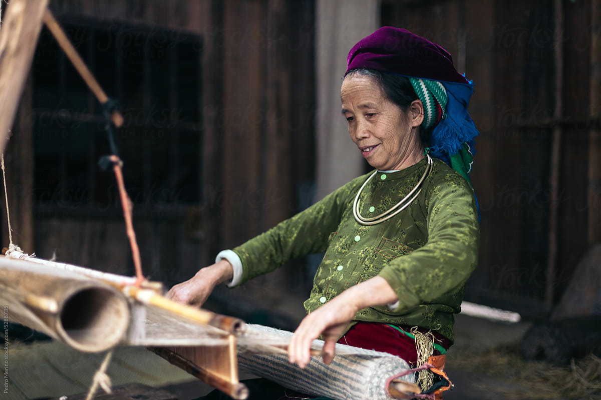 Traditional production: weaver woman working with a loom in a workshop