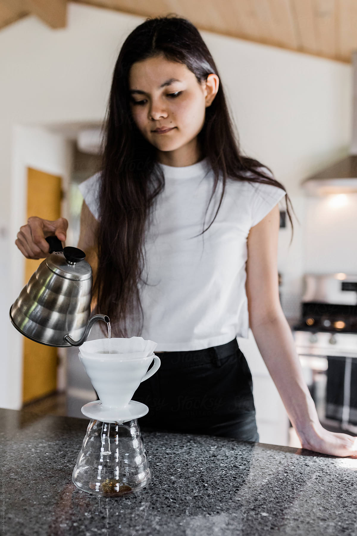 young woman makes craft coffee