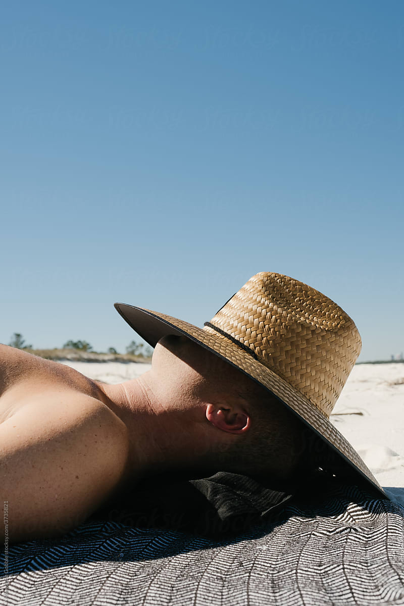 Portrait of Man Sunbathing Under Straw Hat
