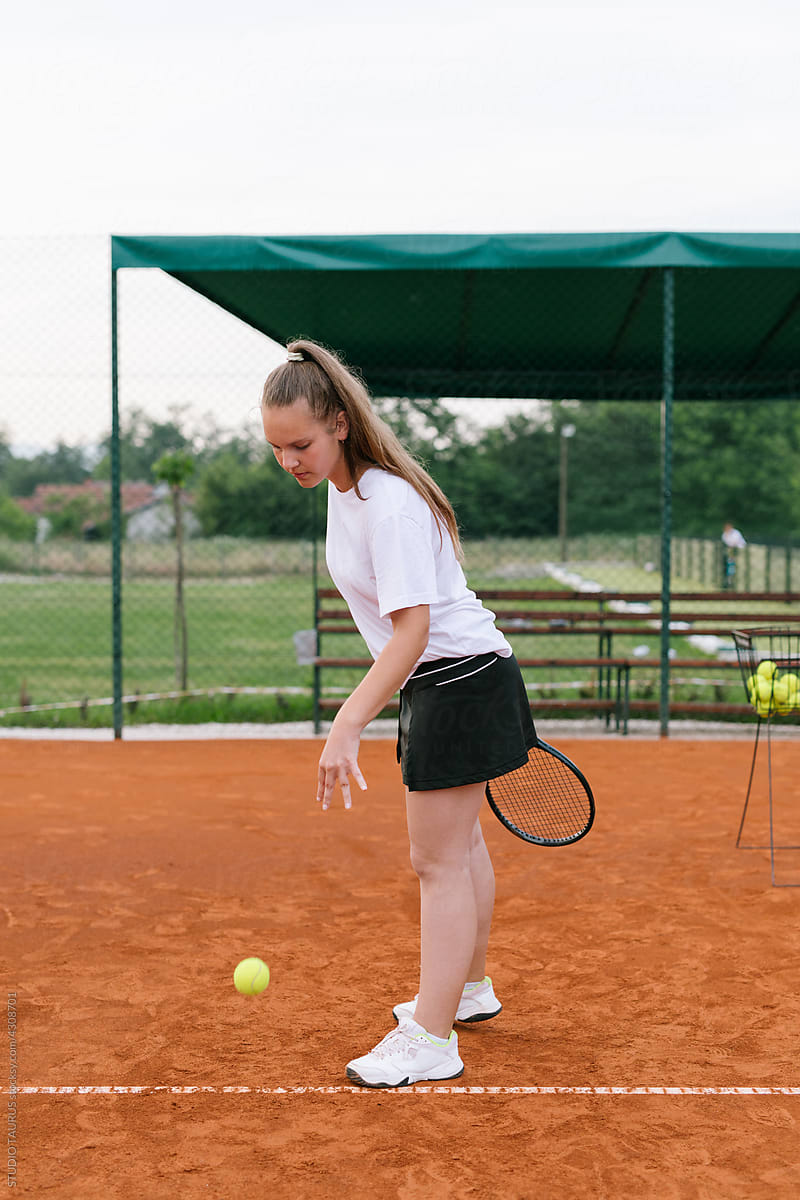 Young student practicing tennis on the tennis court