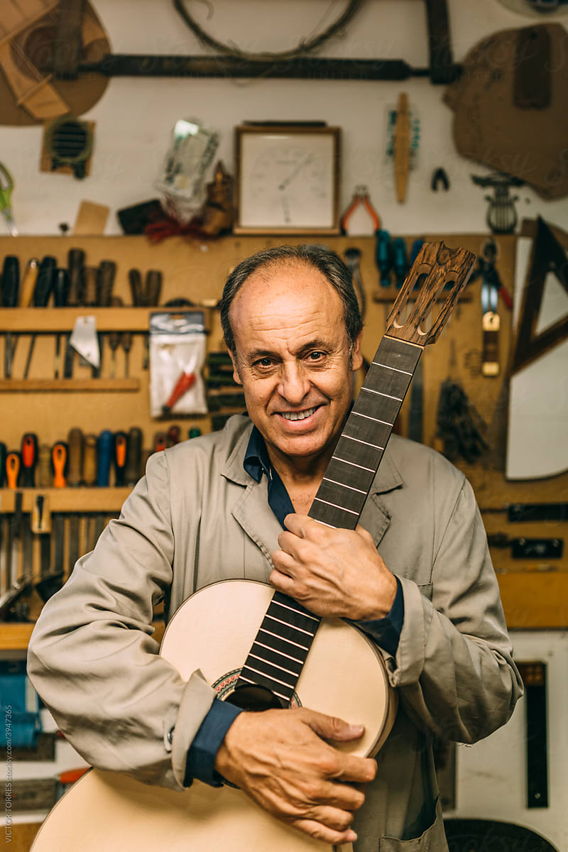 Portrait of senior man holding a custom spanish guitar