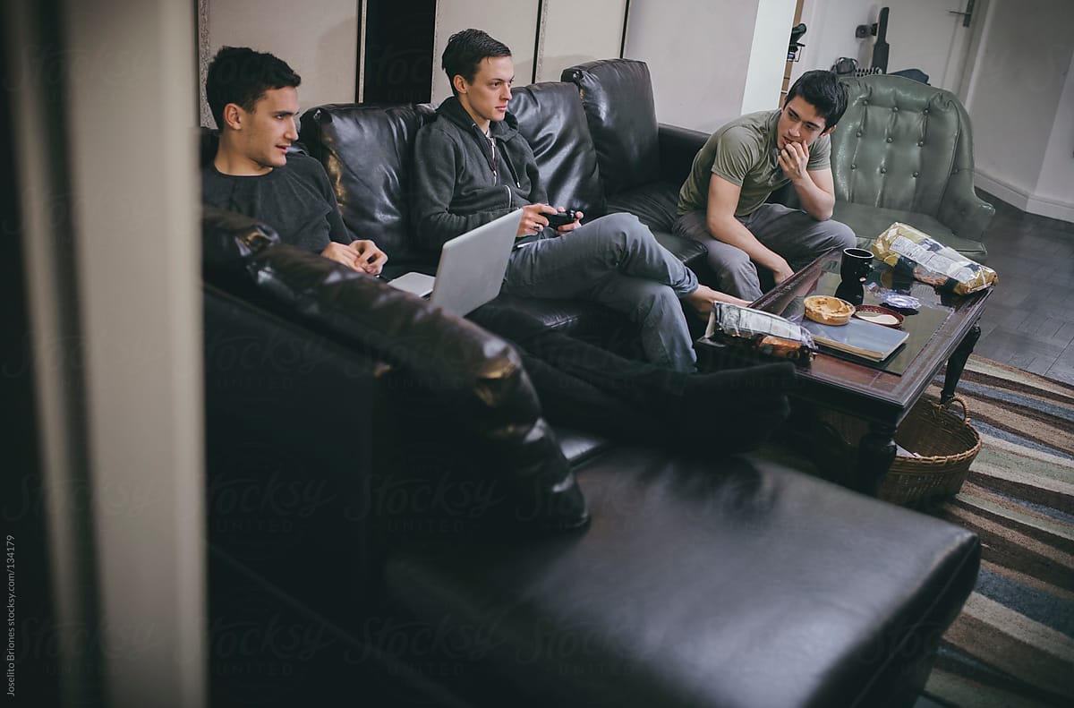 Group of Young Male University Students - Roommates Playing Video Game and Laptop on Couch