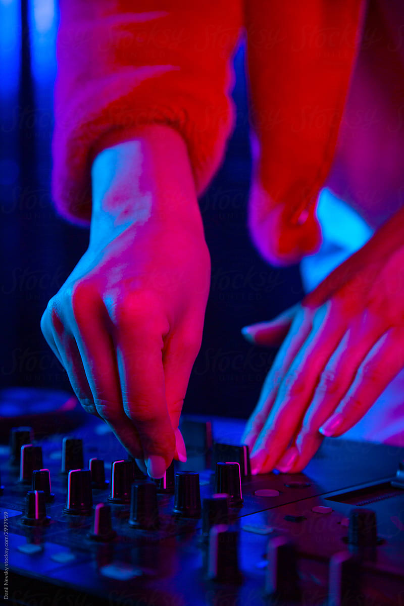 DJ adjusting music at night club party
