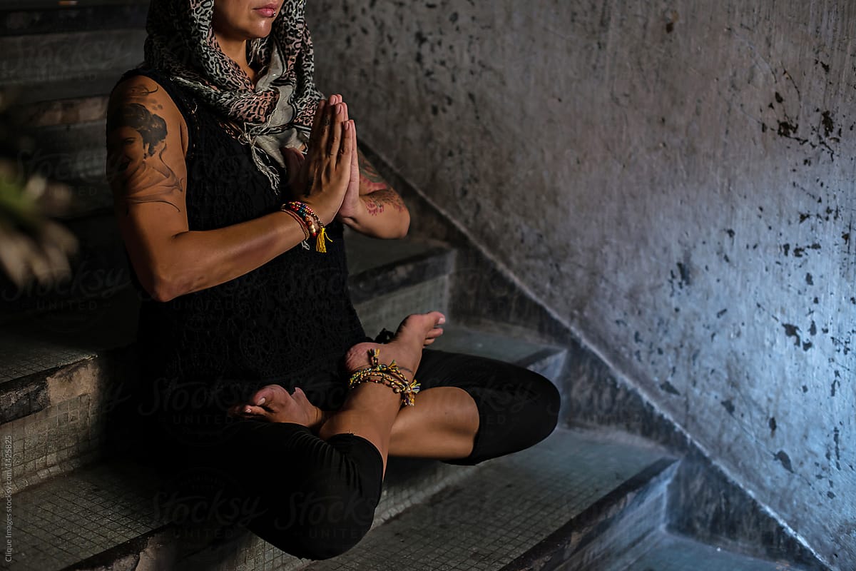 Yogini practicing meditation on staircase