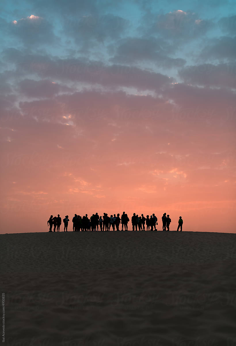 Standing people silhouettes during colourful sunset