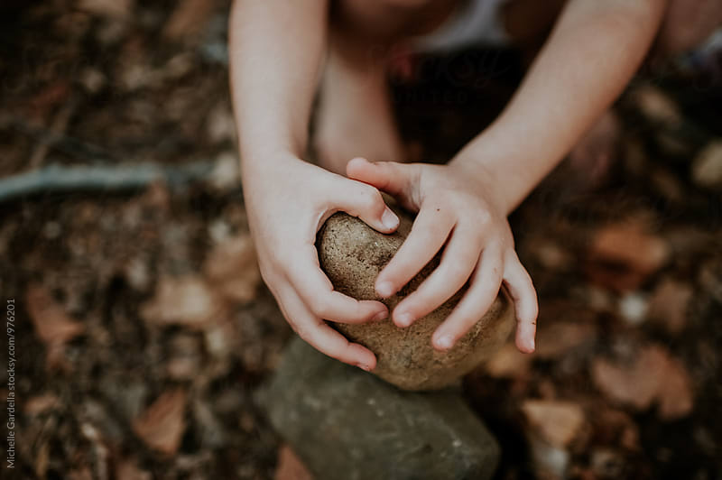 child holding a rock