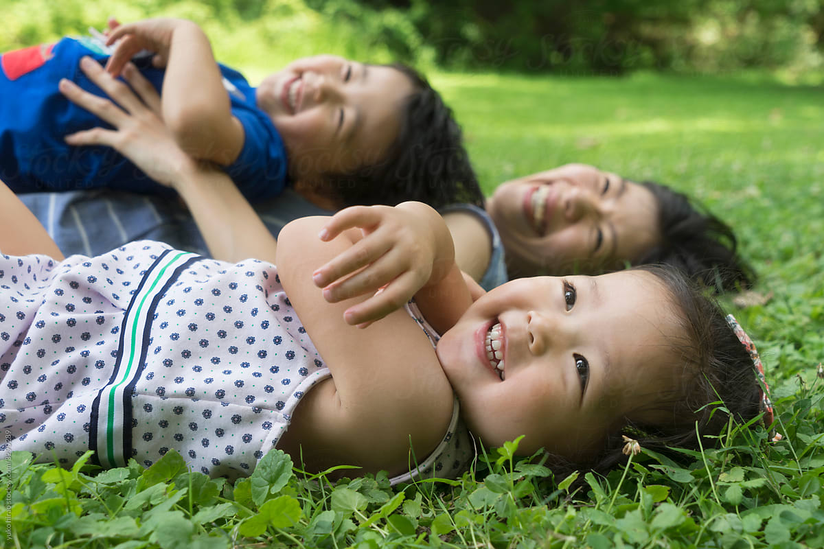 Smiley Asian toddler girl with family on the grass