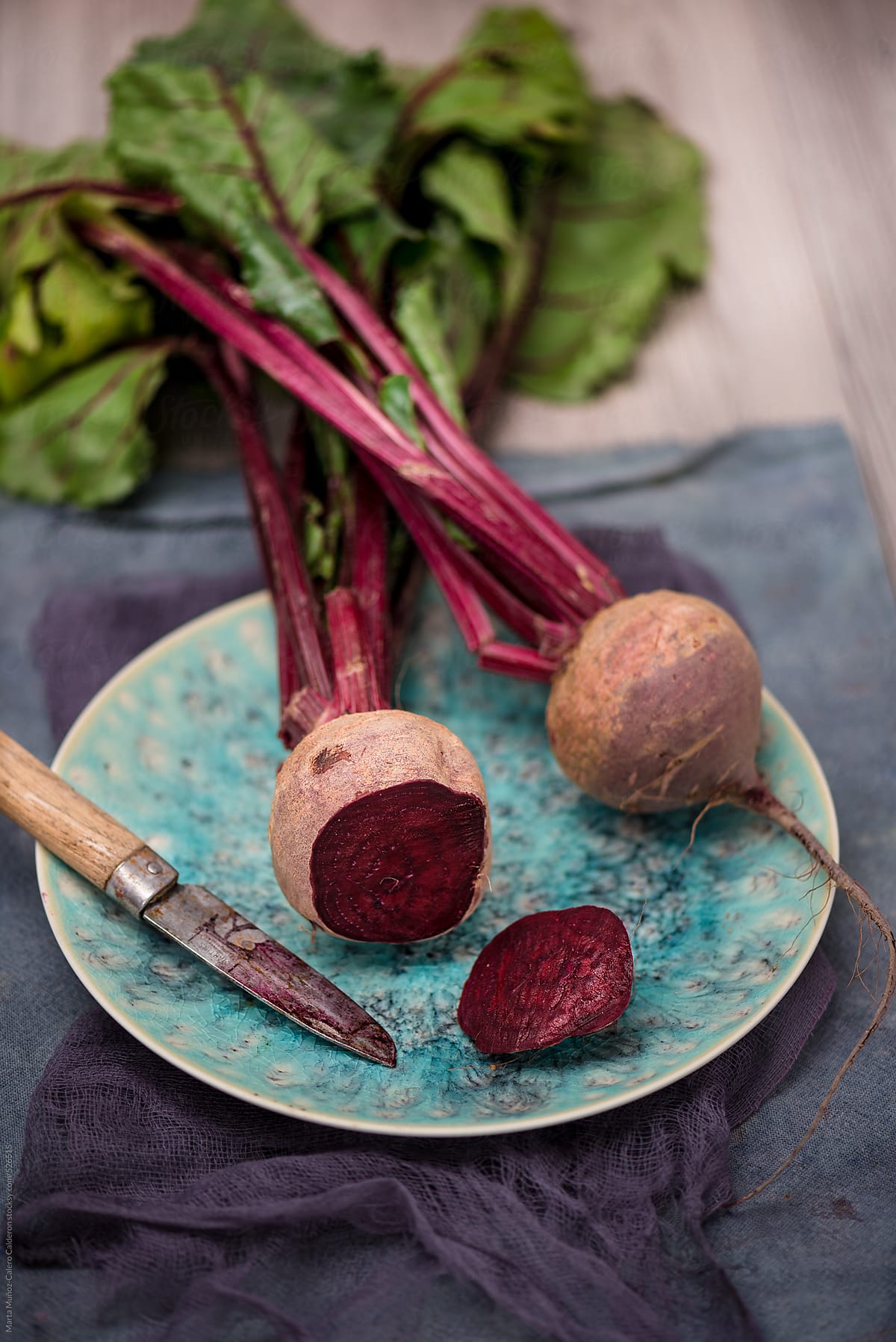 Beets on turquoise porcelain plate on a  rustic wood background