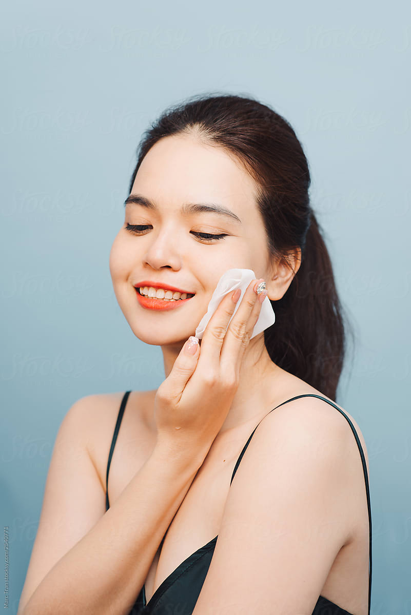 Young woman removing make-up with facial tissues