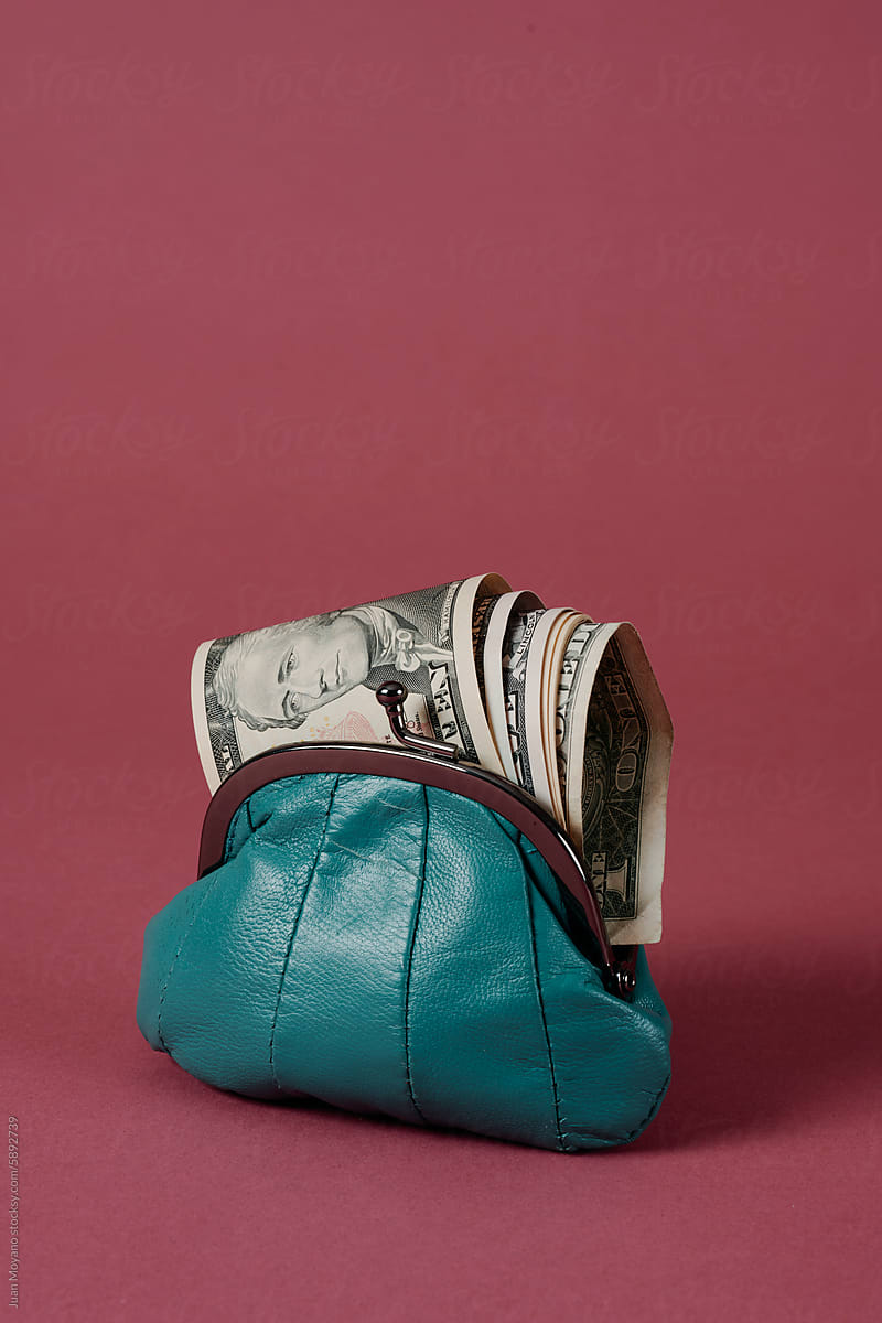 blue leather purse with some dollars