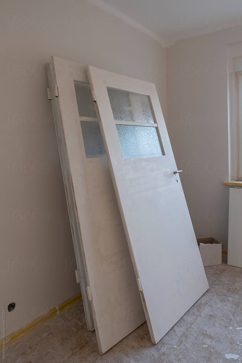 Unhinged doors leaning against wall ready to be painted