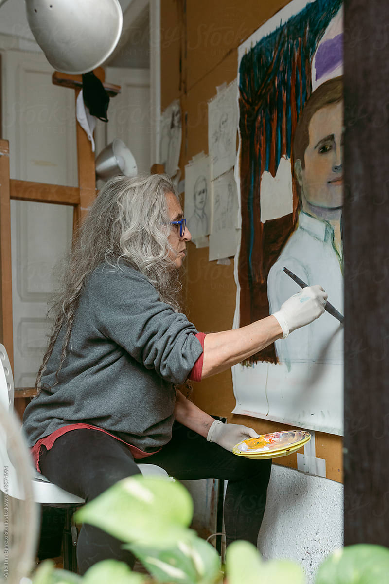 artist woman painting a male portrait