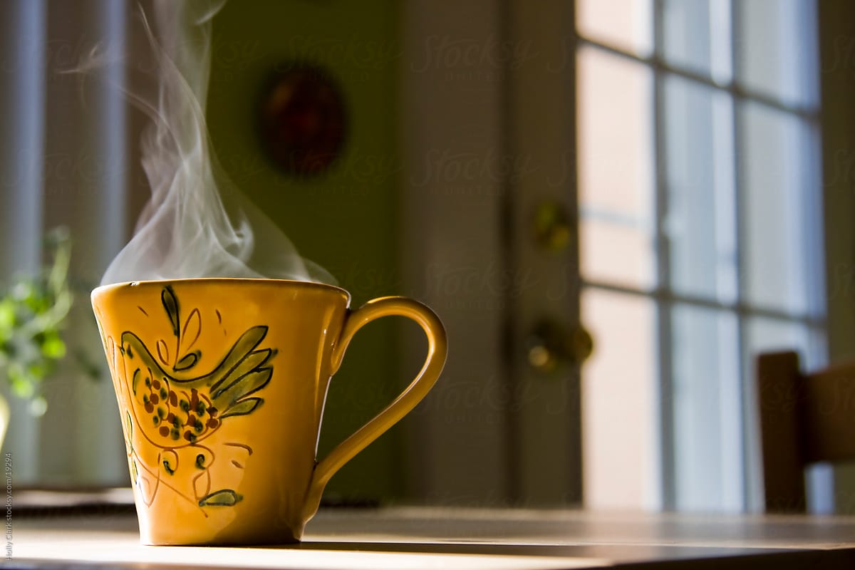Steam rising out of yellow mug on kitchen table