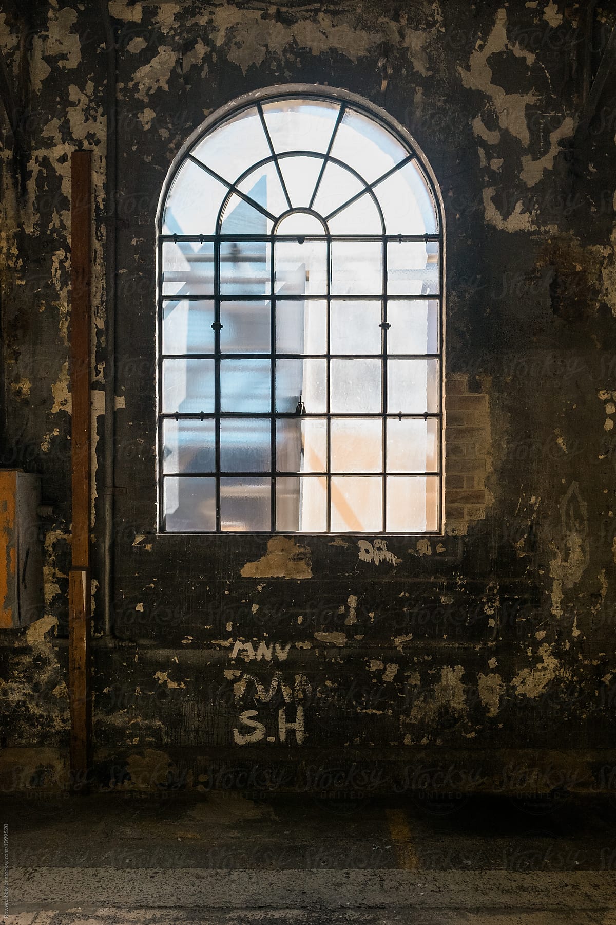 Old arched window in warehouse