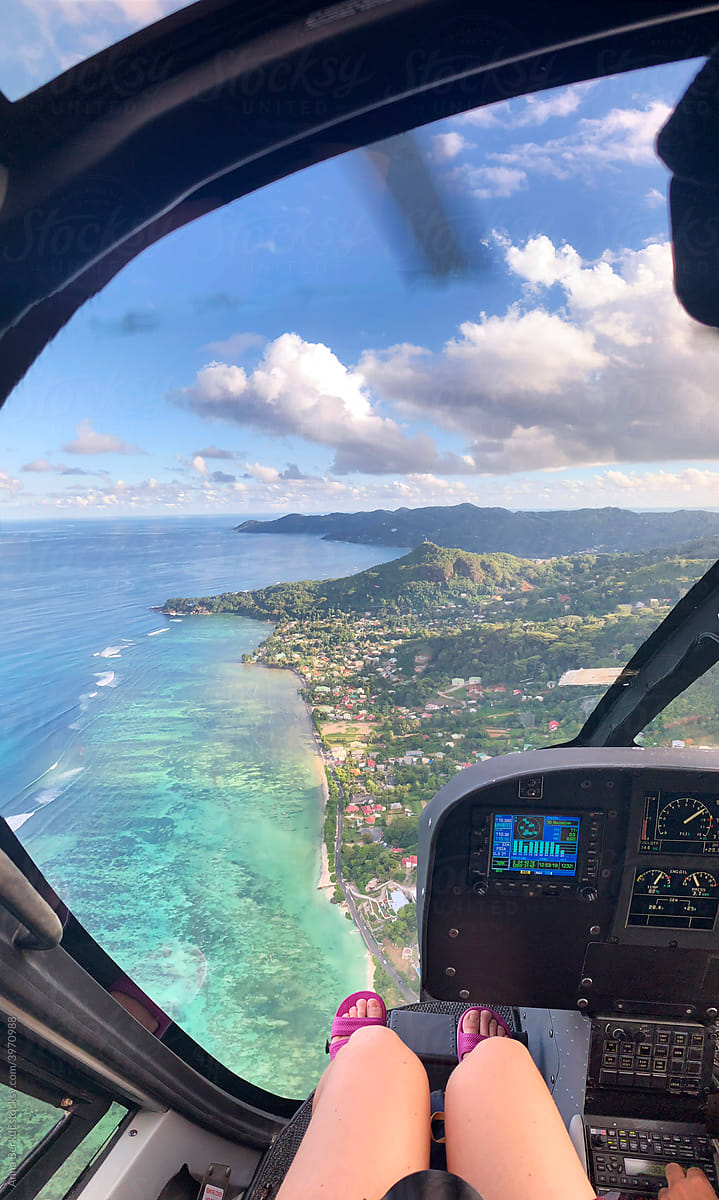 helicopter flight POV, passenger feet, travel to Seychelles