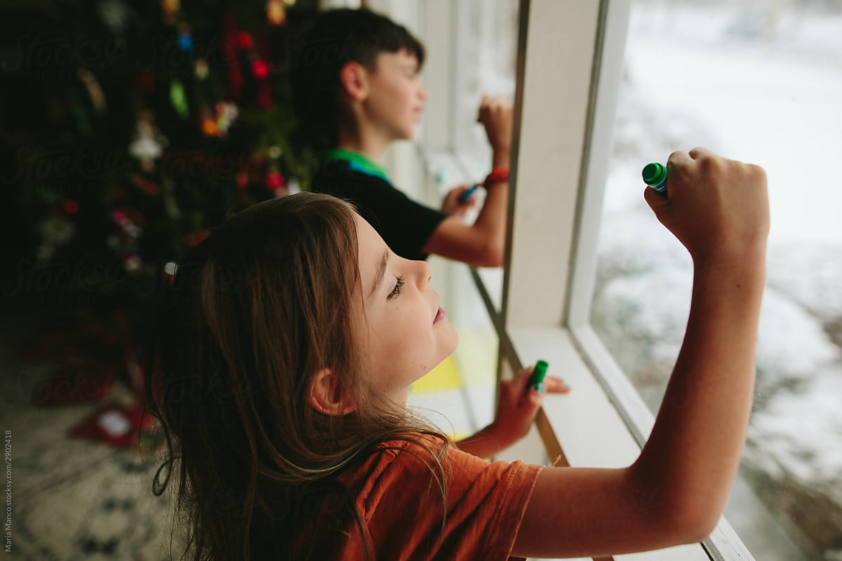 kids write on window with markers