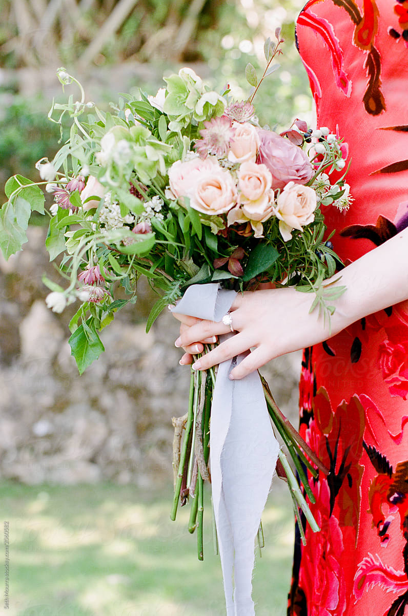Overgrown wild bouquet held by a bride in a traditional red chinese dress