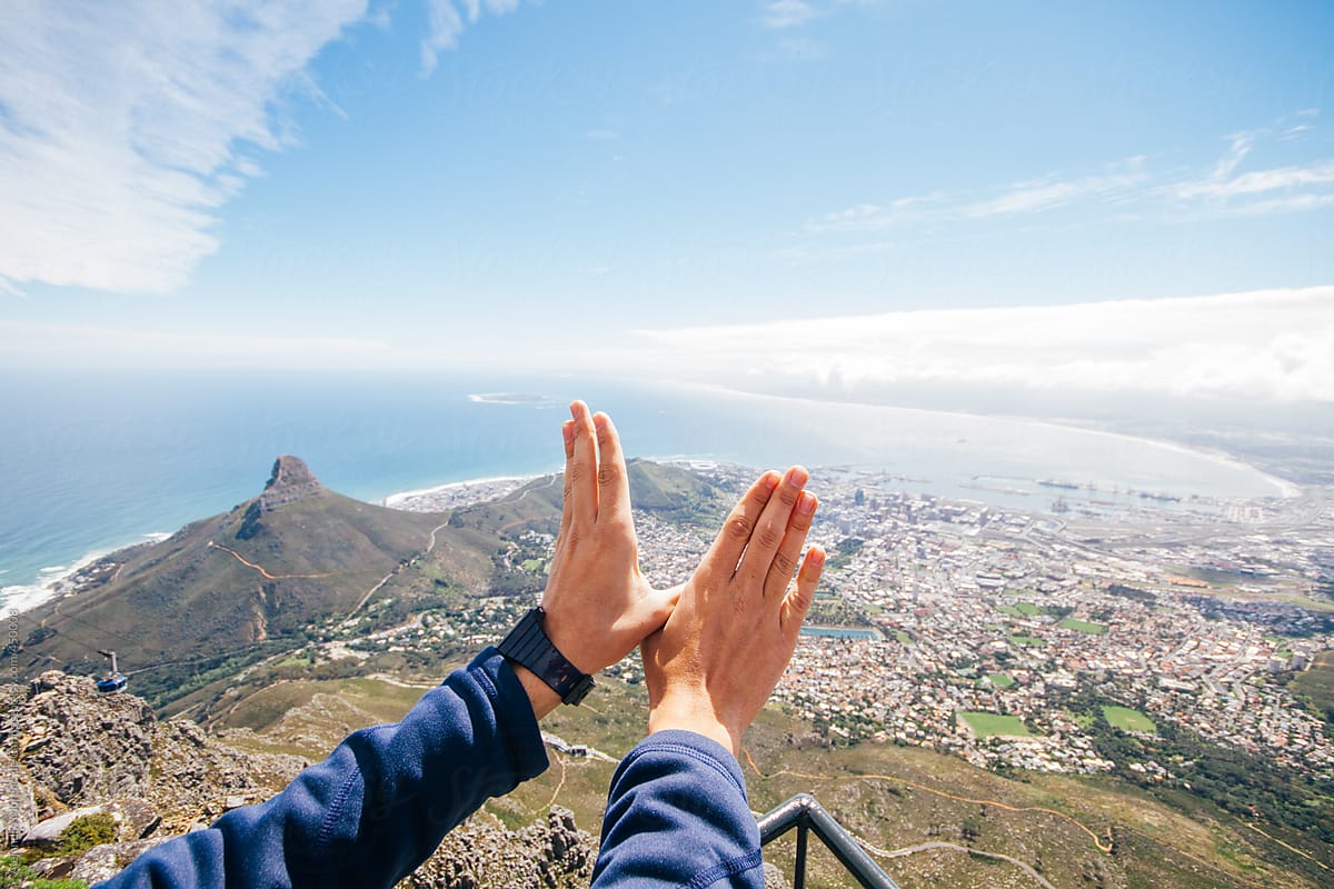 Hands makinng the shape of wings on Table Mountain with the view of the city of Cape Town, South Africa
