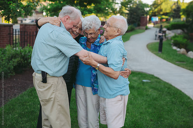 Group of happy, healthy caucasian seniors playing fun game of bocce ball outside