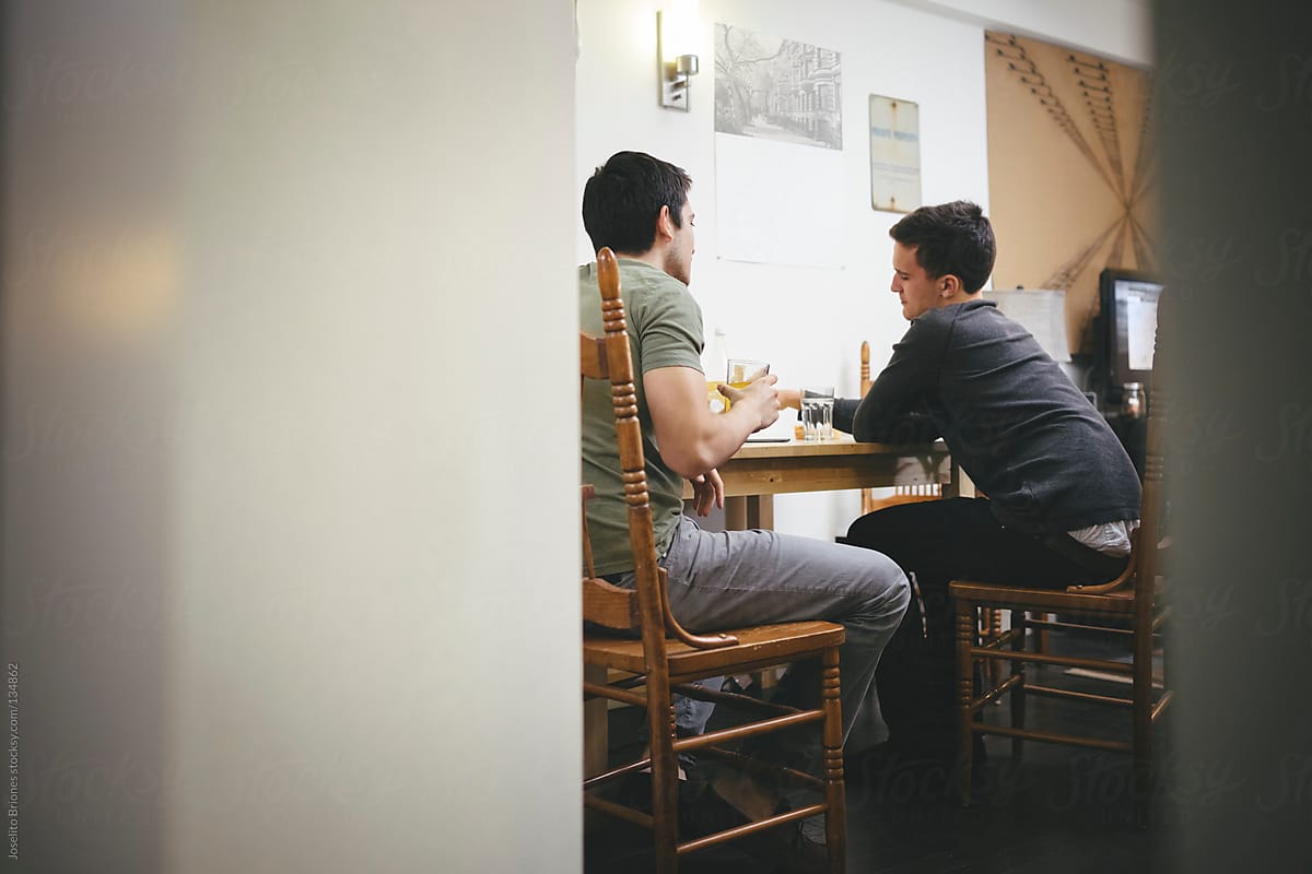 Mexican-American Young Men Friends and Roommates Talking in Dining Table