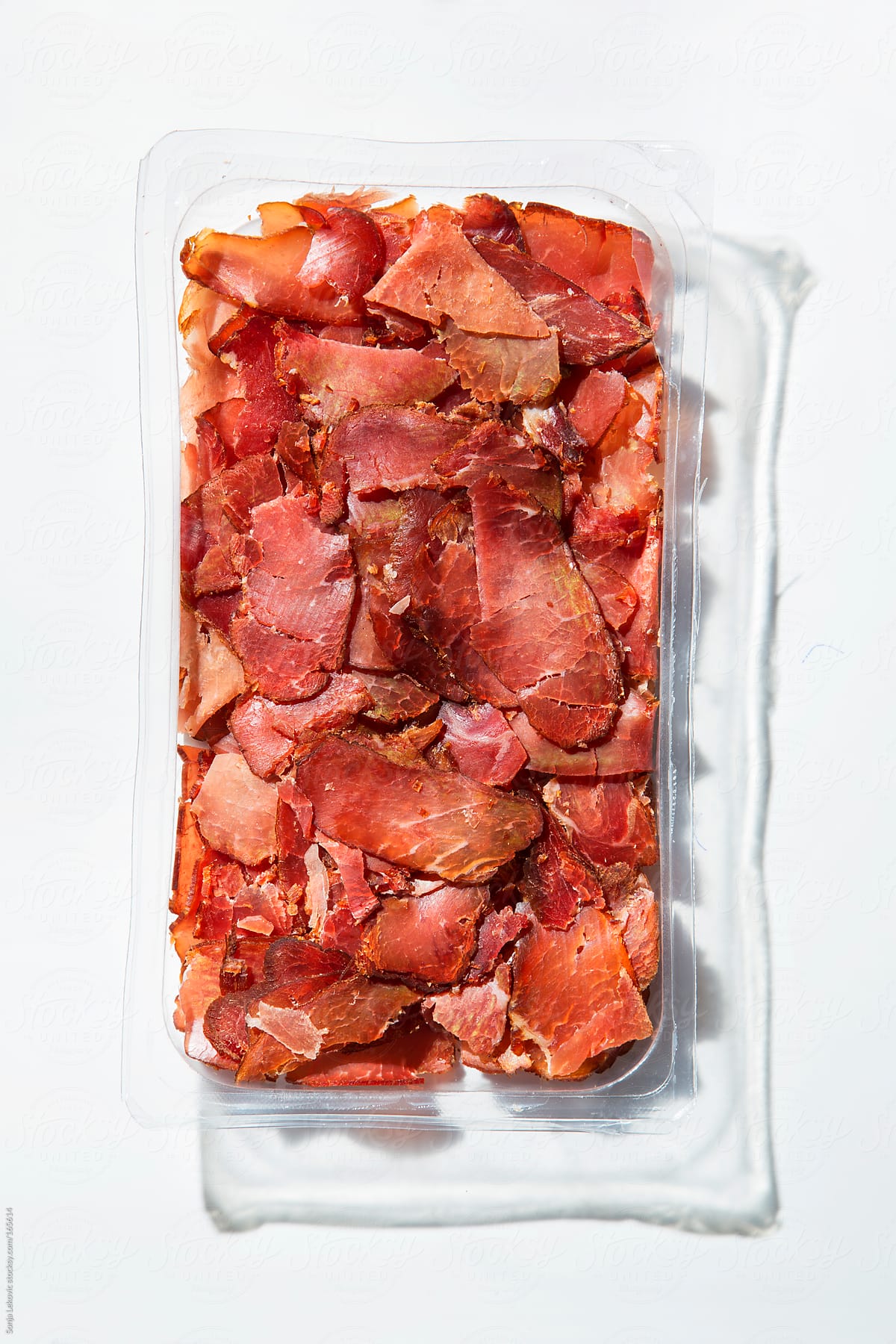 container of dry meat on white
