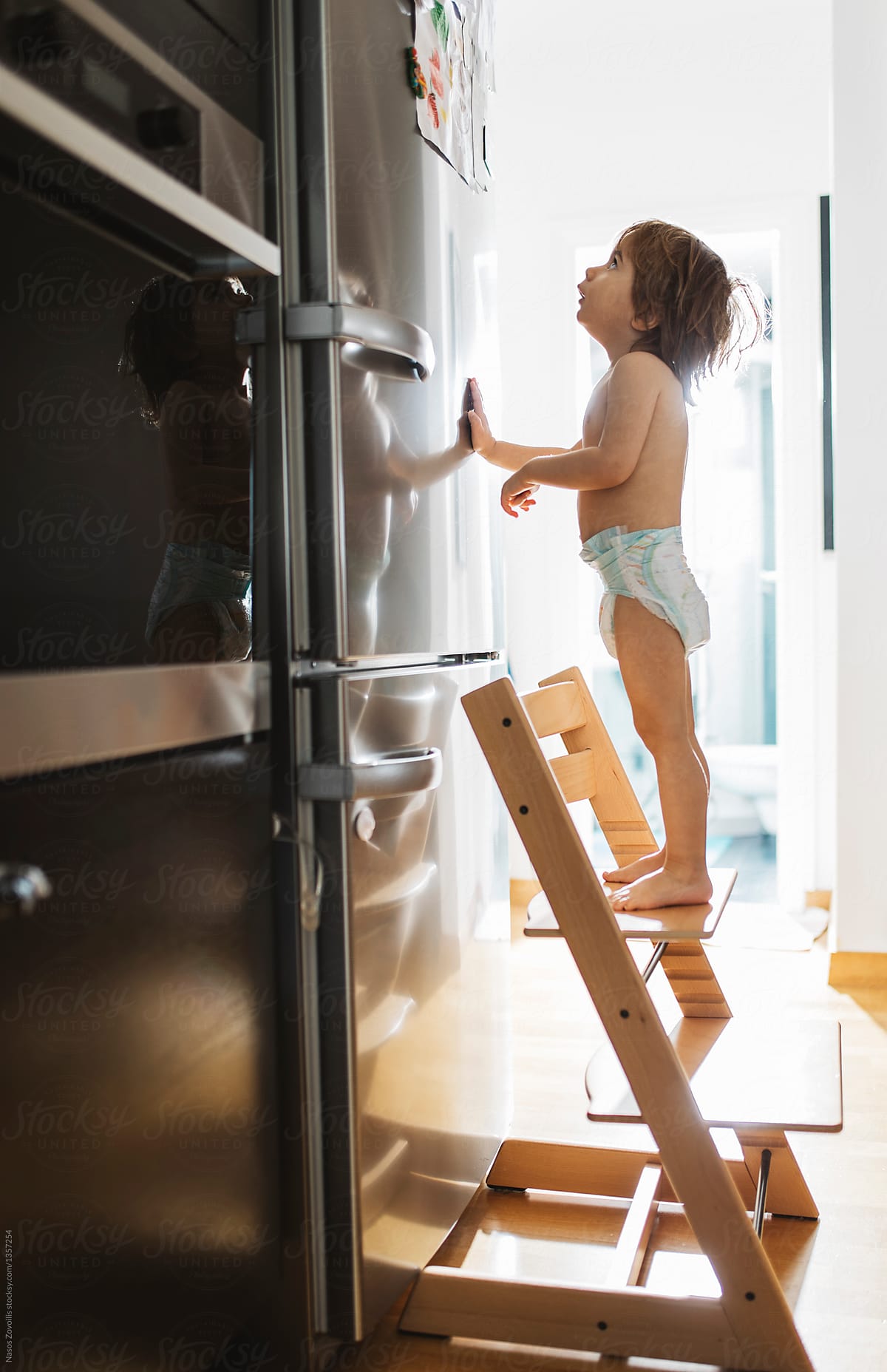 2-year-old-boy-in-front-of-a-refrigerator-del-colaborador-de-stocksy