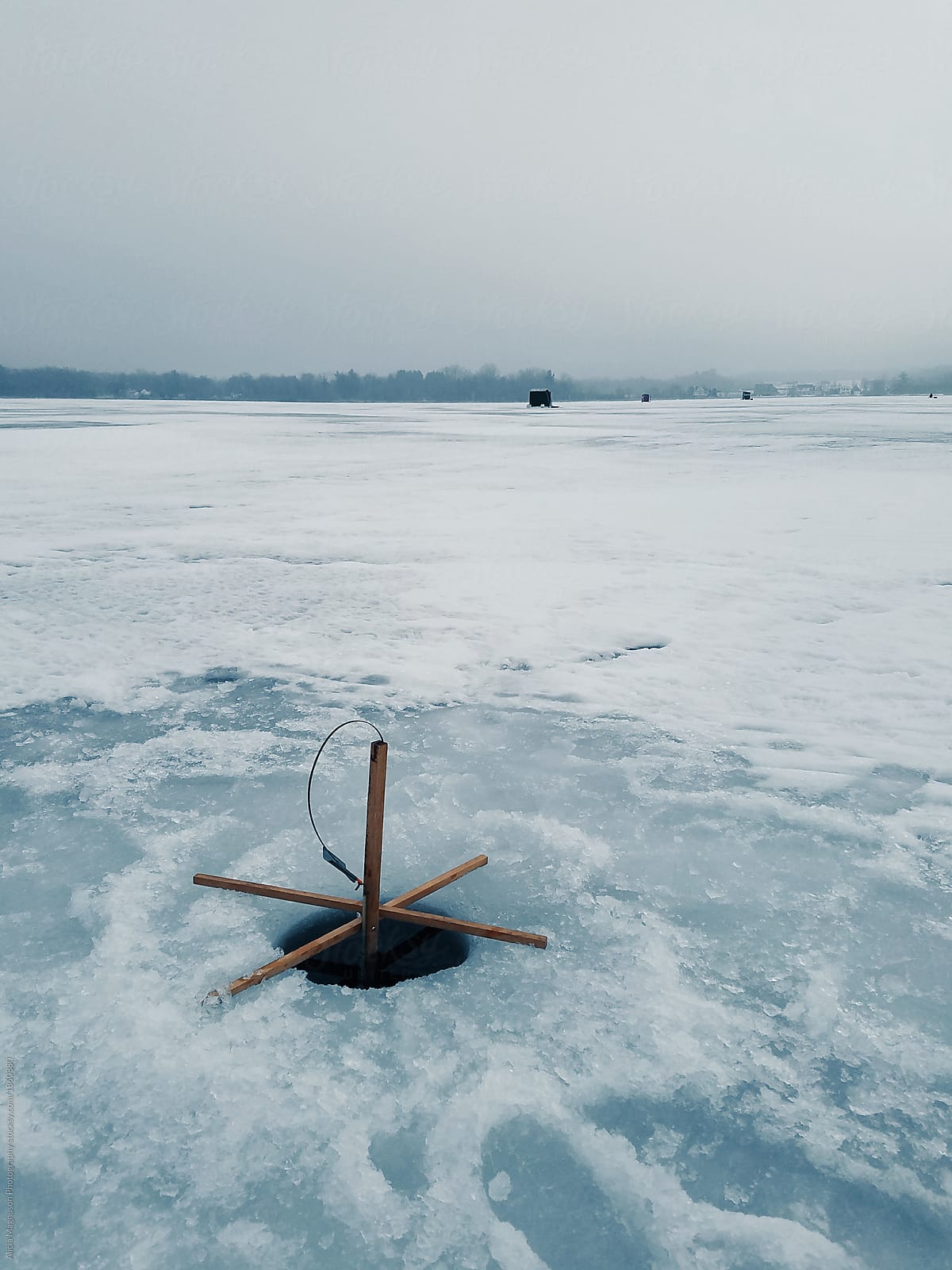 Ice Fishing Tip-Up On Frozen Lake by Stocksy Contributor Alicia Magnuson  Photography - Stocksy
