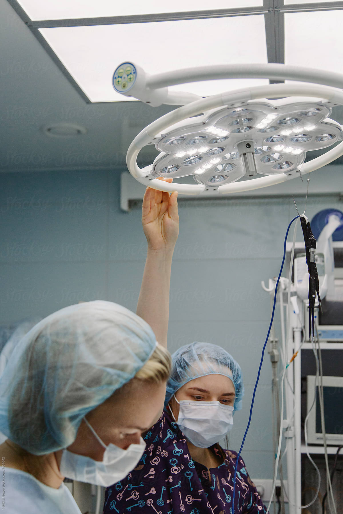 Surgeons setting light in clinic