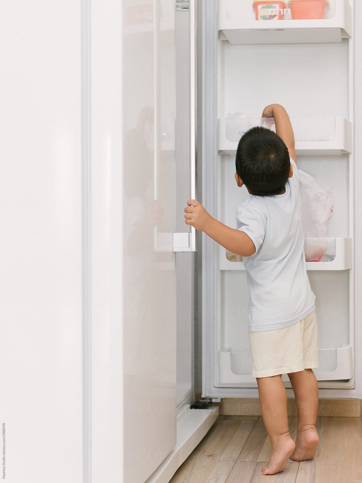 Little boy opening fridge