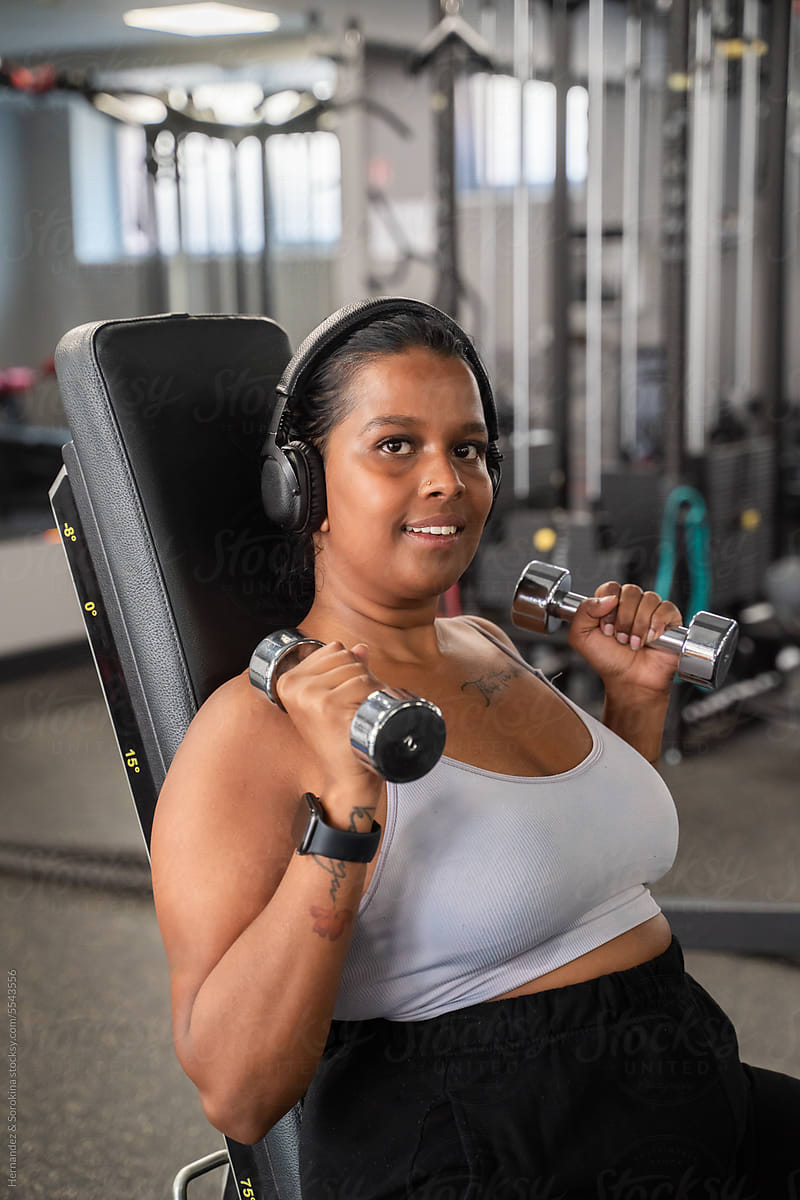 Woman Portrait Working Out With Dumbbells In The Gym
