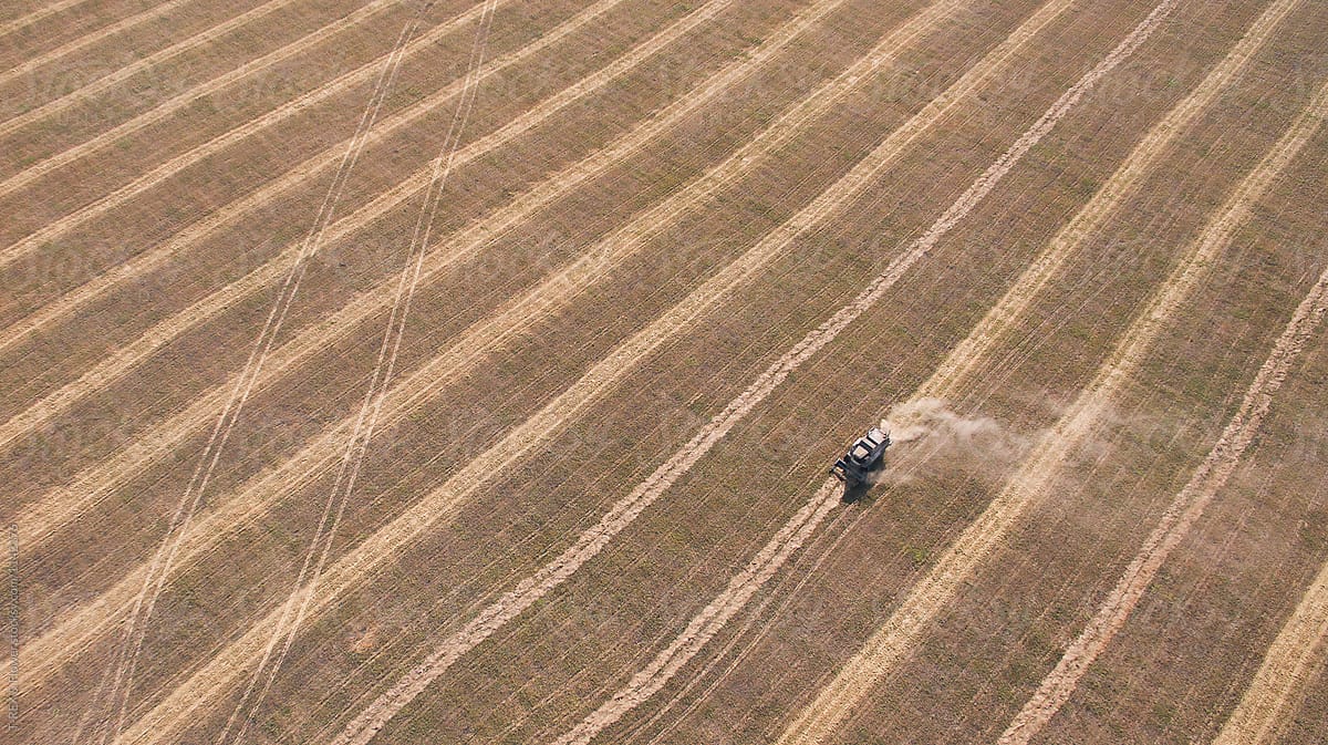 Drone shot of tractor working on hay field.