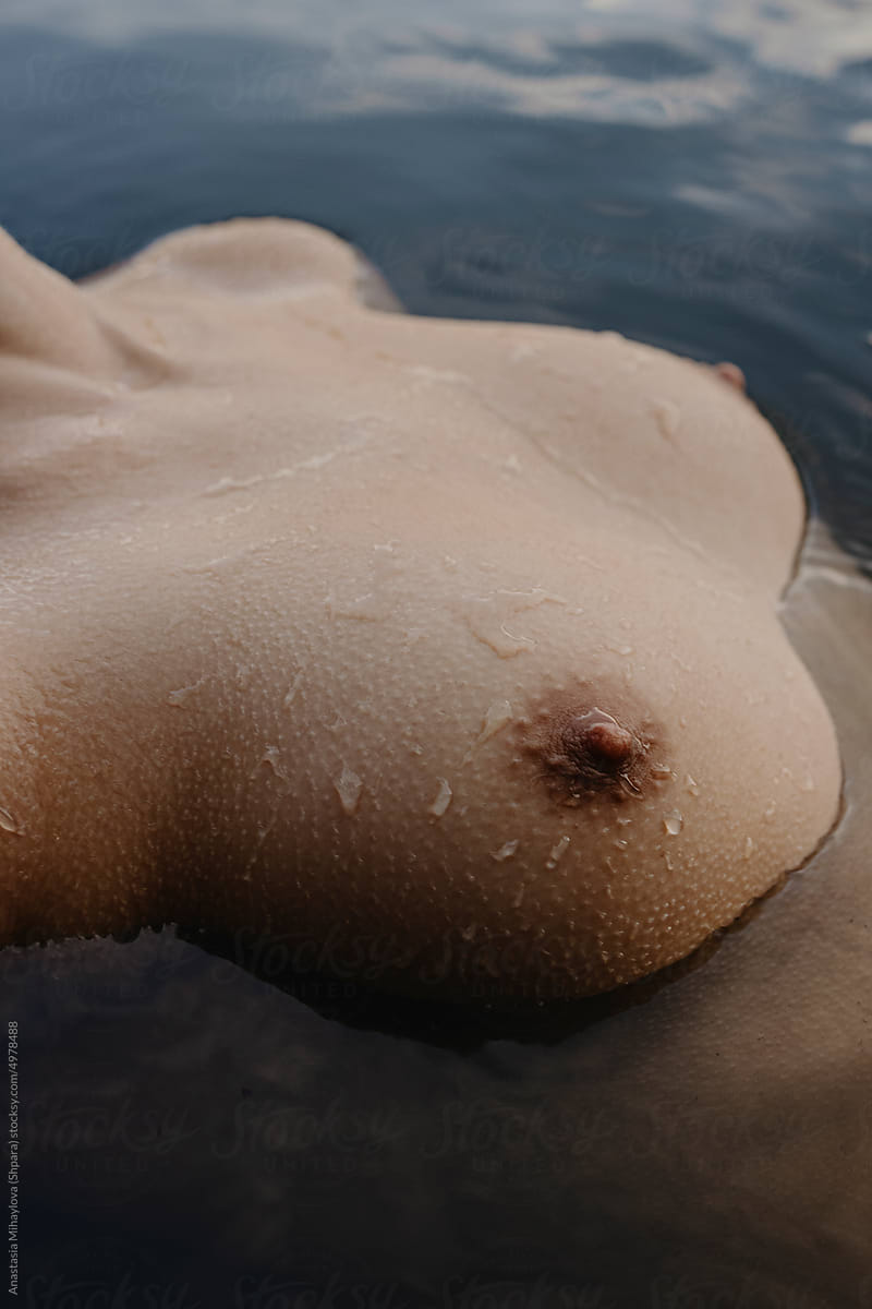 Close up tanned skin texture with water drops of female breast