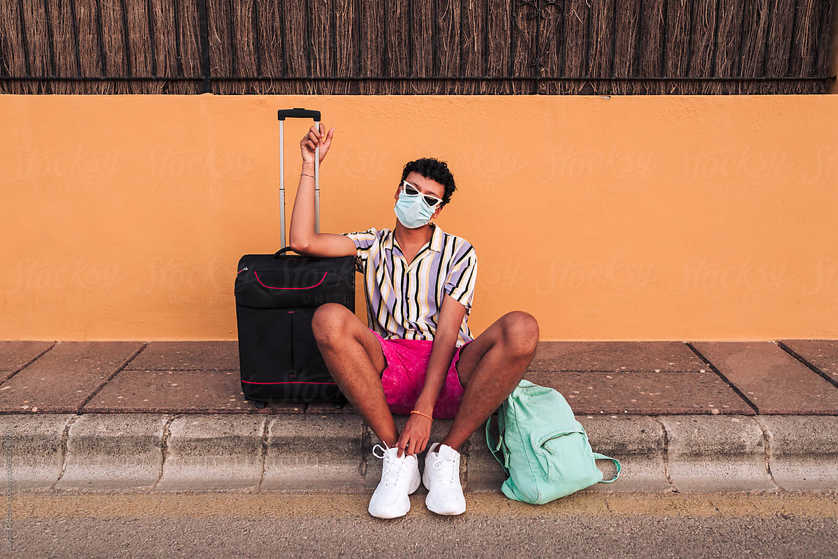 Tourist with a suitcase wearing a face mask