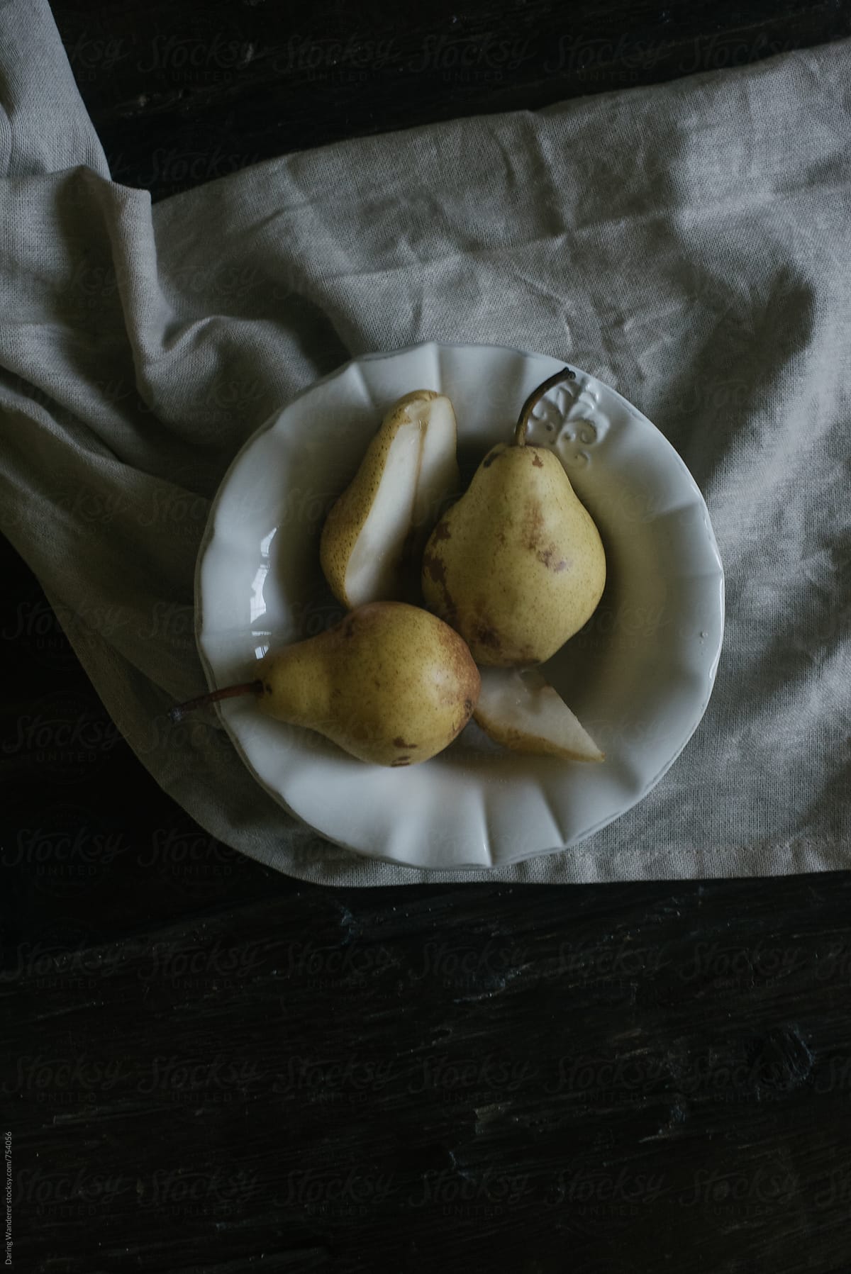 Pears in a bowl on a dark wood table