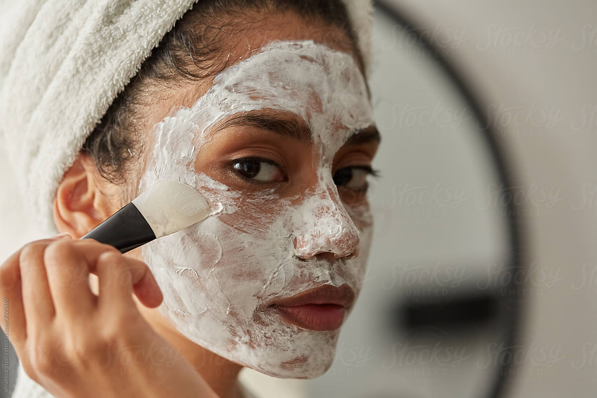 Girl Applying Face Mask Treatment Del Colaborador De Stocksy