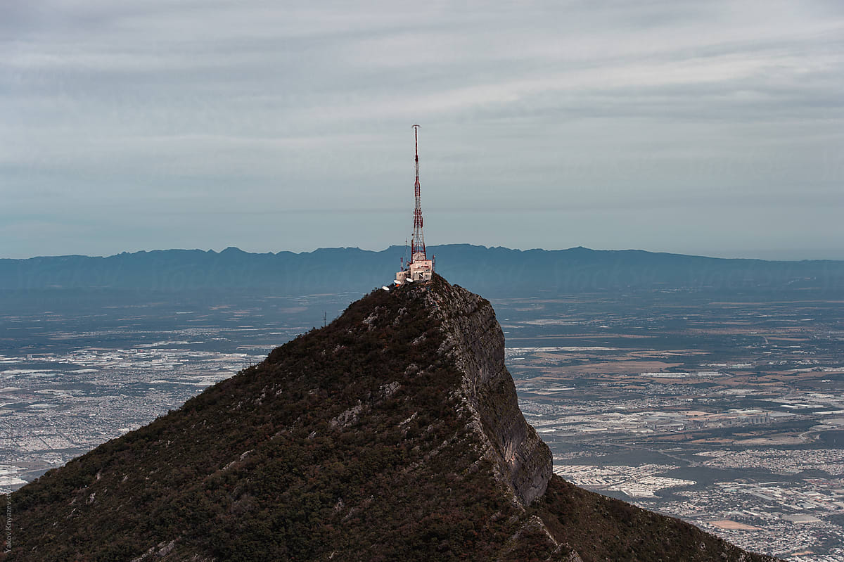 Relay tower on the top of a mountain high above the city line